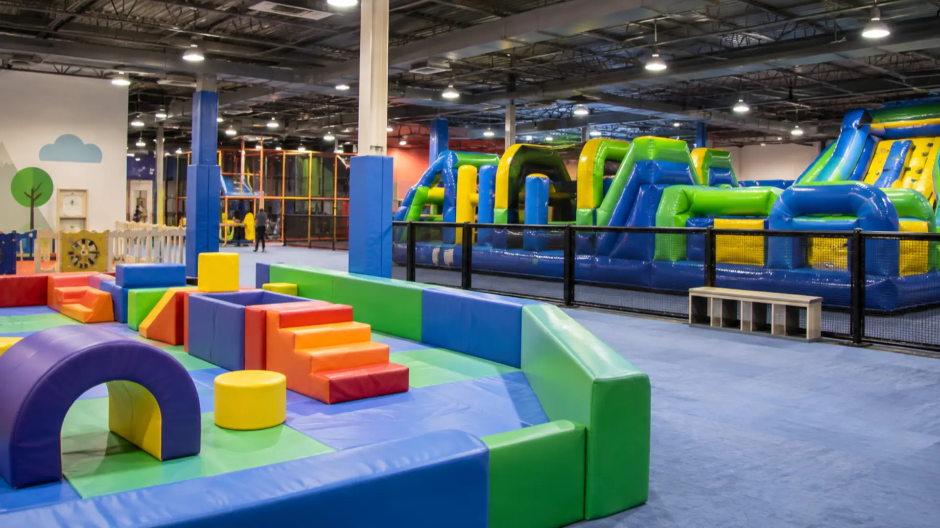 centro de entretenimiento familiar interior con zonas de juego inflables separadas para niños pequeños y en edad escolar